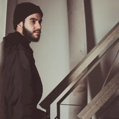 A man with a shaped full beard and a dark beanie